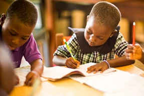 Children writing at their desk in Ghana